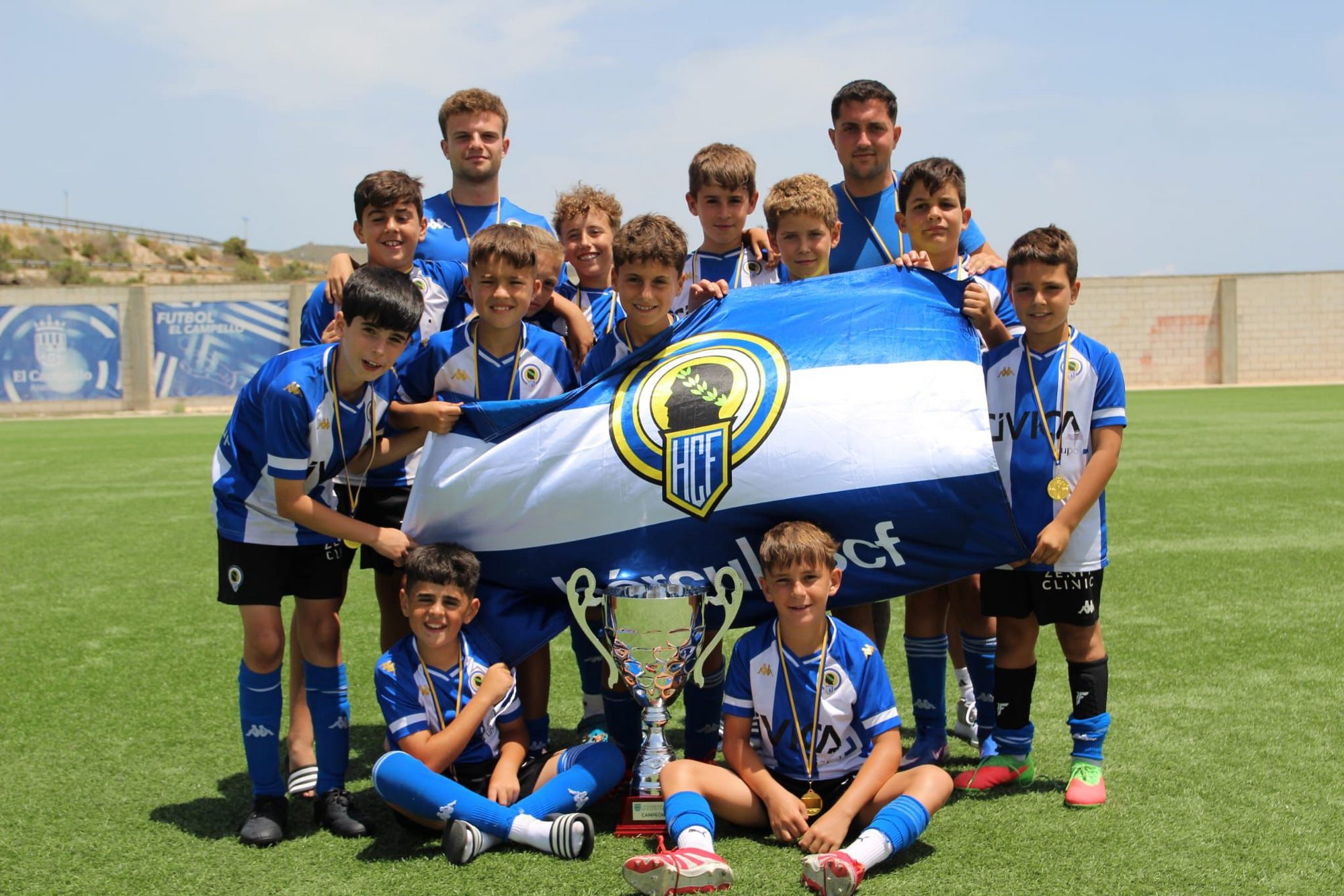 Jugadores de la cantera del Hércules CF celebrando con trofeo y bandera
