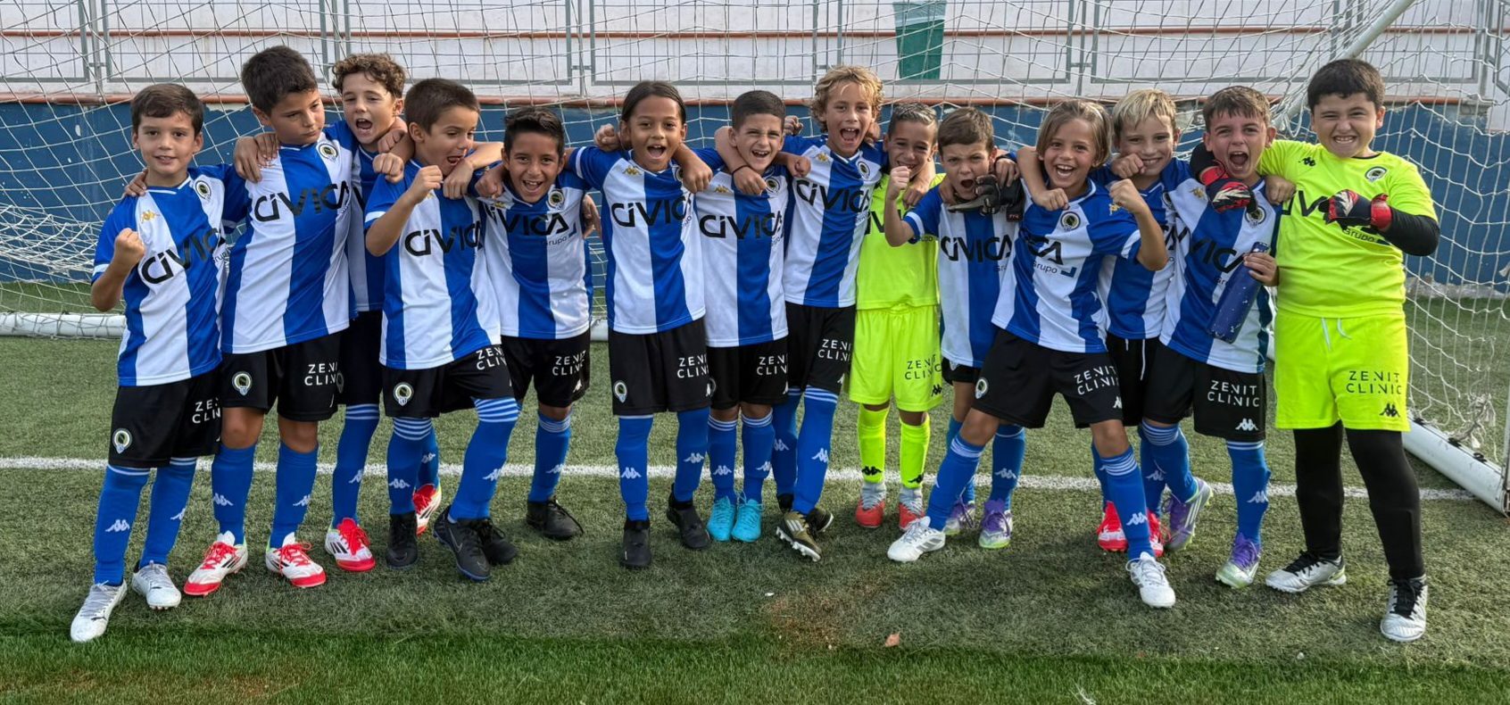 Niños de la cantera del Hércules celebrando en el campo